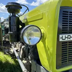 Ciągnik Ursus C330, zielony, z widocznym filtrem powietrza i reflektorem. Prawidłowe ciśnienie w oponach C330 to klucz do efektywnej pracy.