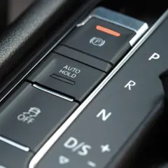 Przycisk AUTO HOLD w samochodzie. Ułatwia postój, zapobiegając stoczeniu się pojazdu.