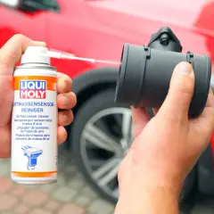 Czyszczenie przepływomierza: ręka trzyma puszkę preparatu Liqui Moly i aplikuje go na element.