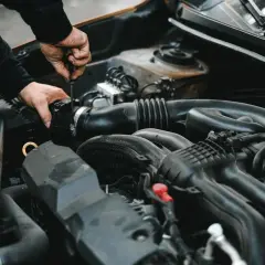 Mechanik dokręca śrubę przy silniku. Może to być związane z uszkodzonym przekaźnikiem pompy paliwa objawy, które utrudniają pracę auta.