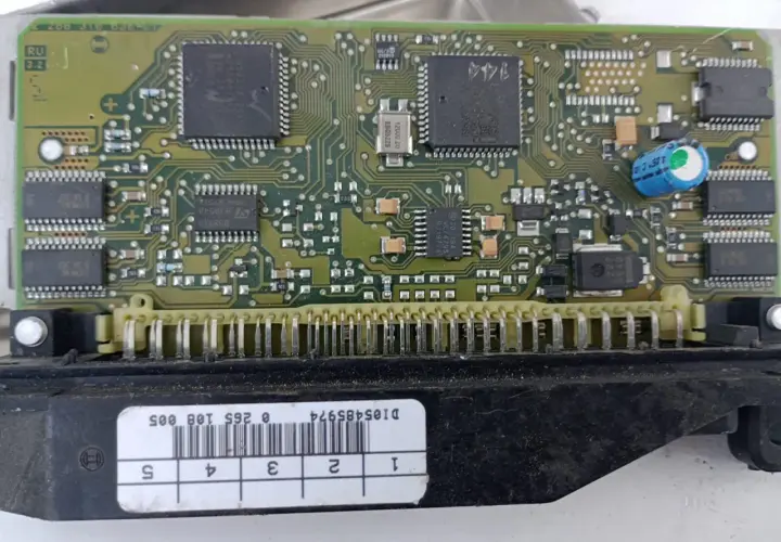 Elektronika sterująca budową pompy ABS. Widoczny zielony laminat z układami scalonymi, kondensatorami i złączem.