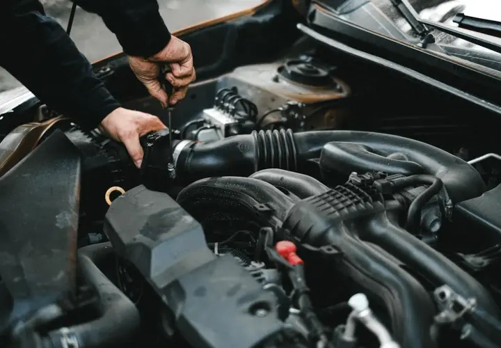 Mechanik dokręca śrubę przy silniku. Może to być związane z uszkodzonym przekaźnikiem pompy paliwa objawy, które utrudniają pracę auta.