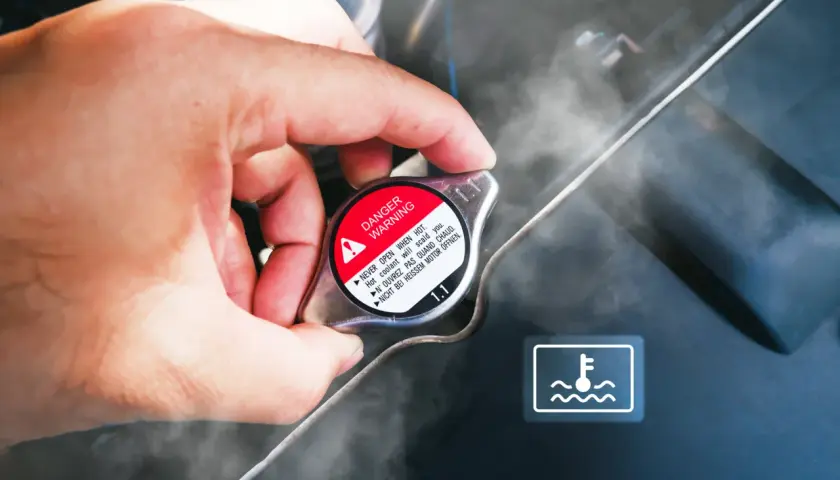 Dłoń dotyka korka chłodnicy, z którego wydobywa się para. Widoczny symbol ostrzegawczy i napis "DANGER WARNING". Sygnalizuje to prawdopodobnie **mało płynu w chłodnicy**.
