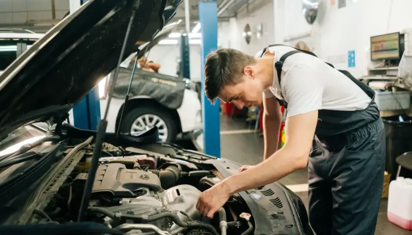 Mechanik sprawdza silnik, podejrzewając przepuszczającą pompę hamulcową.