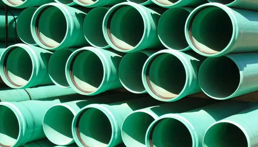 Zielone rury PVC ułożone w stosy, gotowe do tworzenia systemów łączenia rur wodnych.