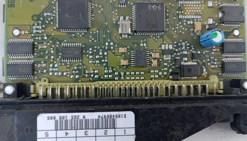 Elektronika sterująca budową pompy ABS. Widoczny zielony laminat z układami scalonymi, kondensatorami i złączem.