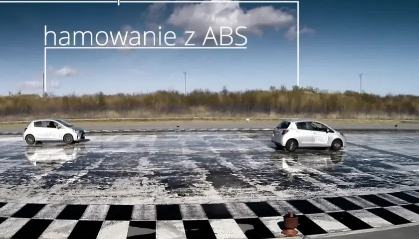 Dwa samochody na mokrej nawierzchni. Jeden wykonuje hamowanie progresywne z ABS, drugi hamuje bez.