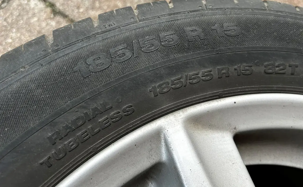 Opona radial tubeless 185/55 R15. Widoczny rozmiar i oznaczenie radial tubeless na oponie samochodowej.